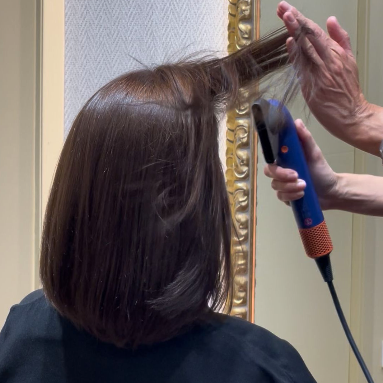 Una mujer secándose el cabello.
