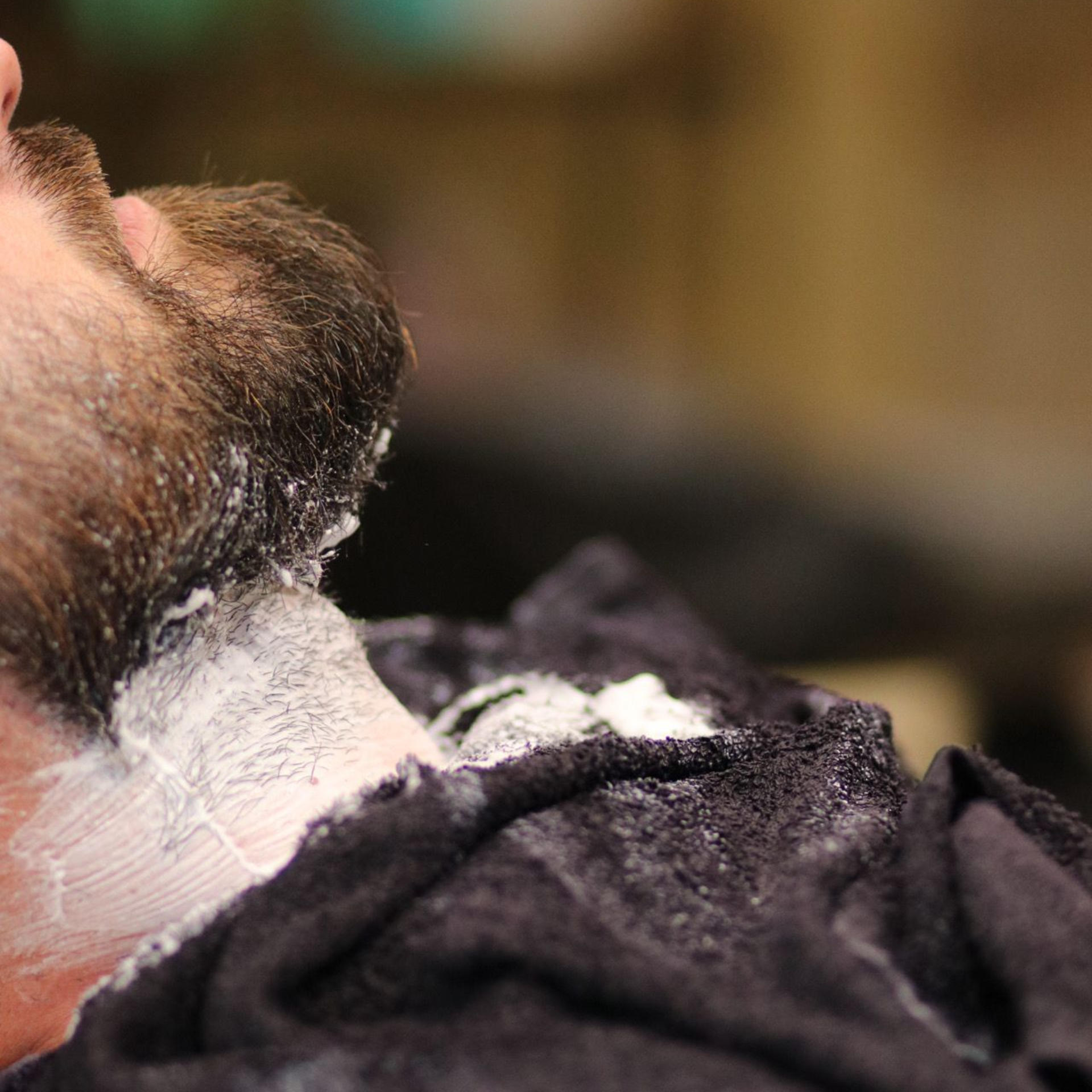 Un barbero le afeita la barba a un hombre
