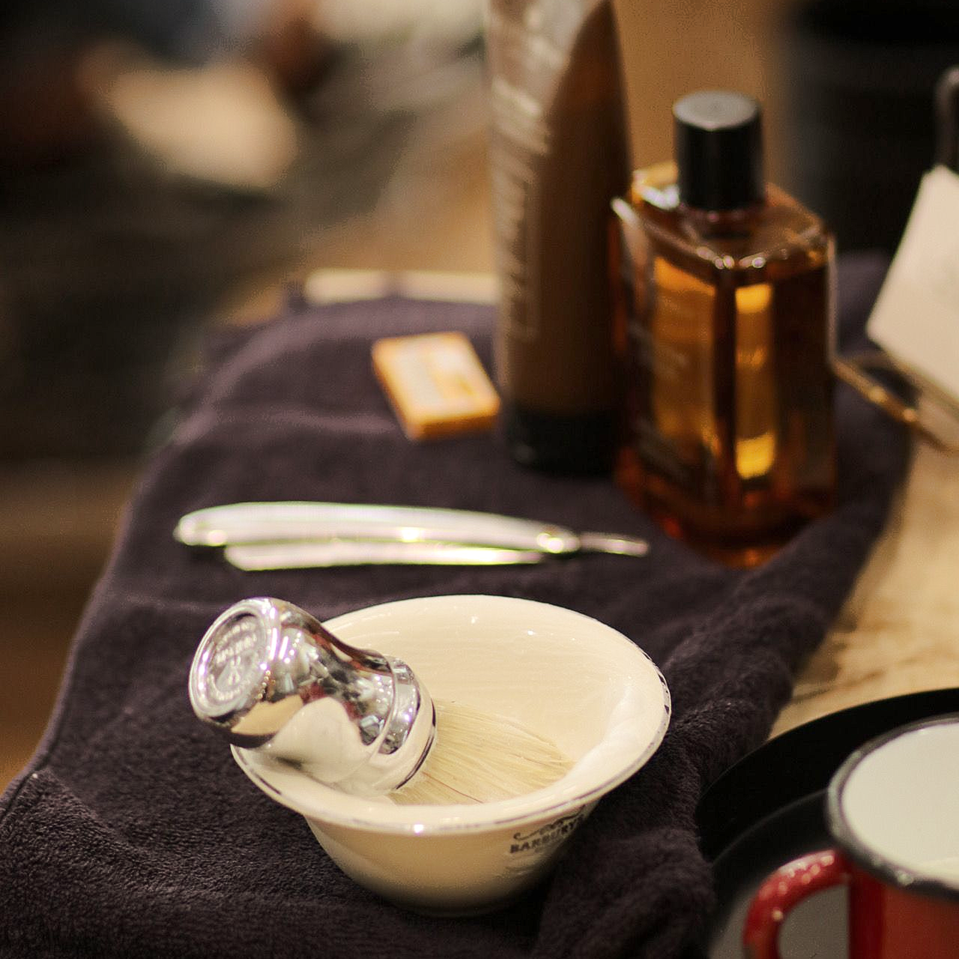 Un cuenco de plata con una brocha de afeitar.