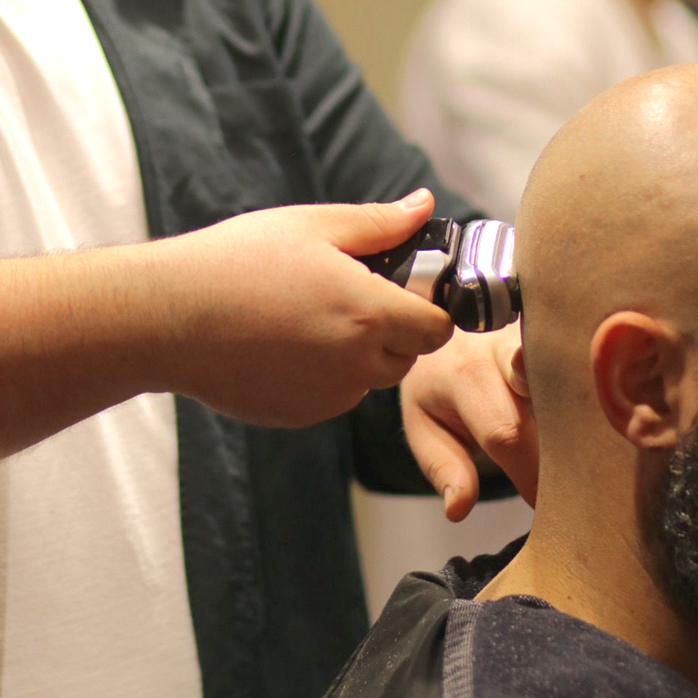 Un hombre se está cortando el pelo con una maquinilla