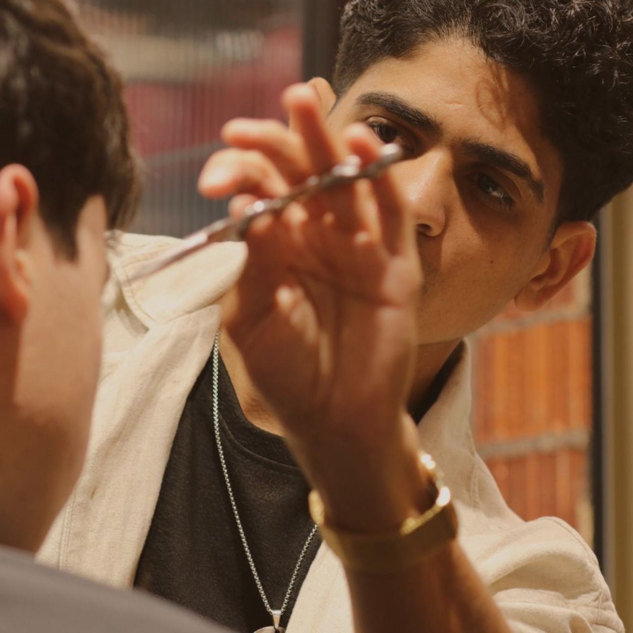 Un barbero le está cortando el pelo a un hombre con una maquinilla.