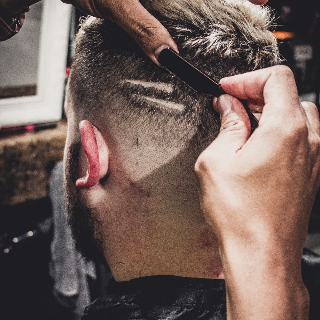 Un barbero le corta el pelo a un hombre