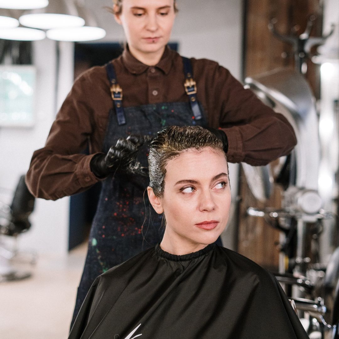 Una mujer se tiñe el pelo en un salón.