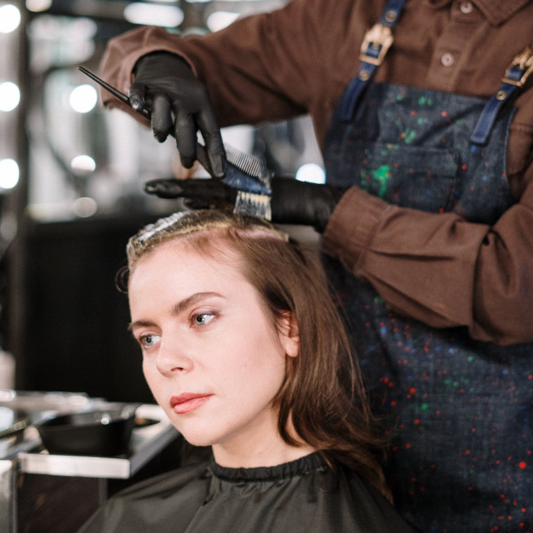 Una mujer se tiñe el pelo en un salón