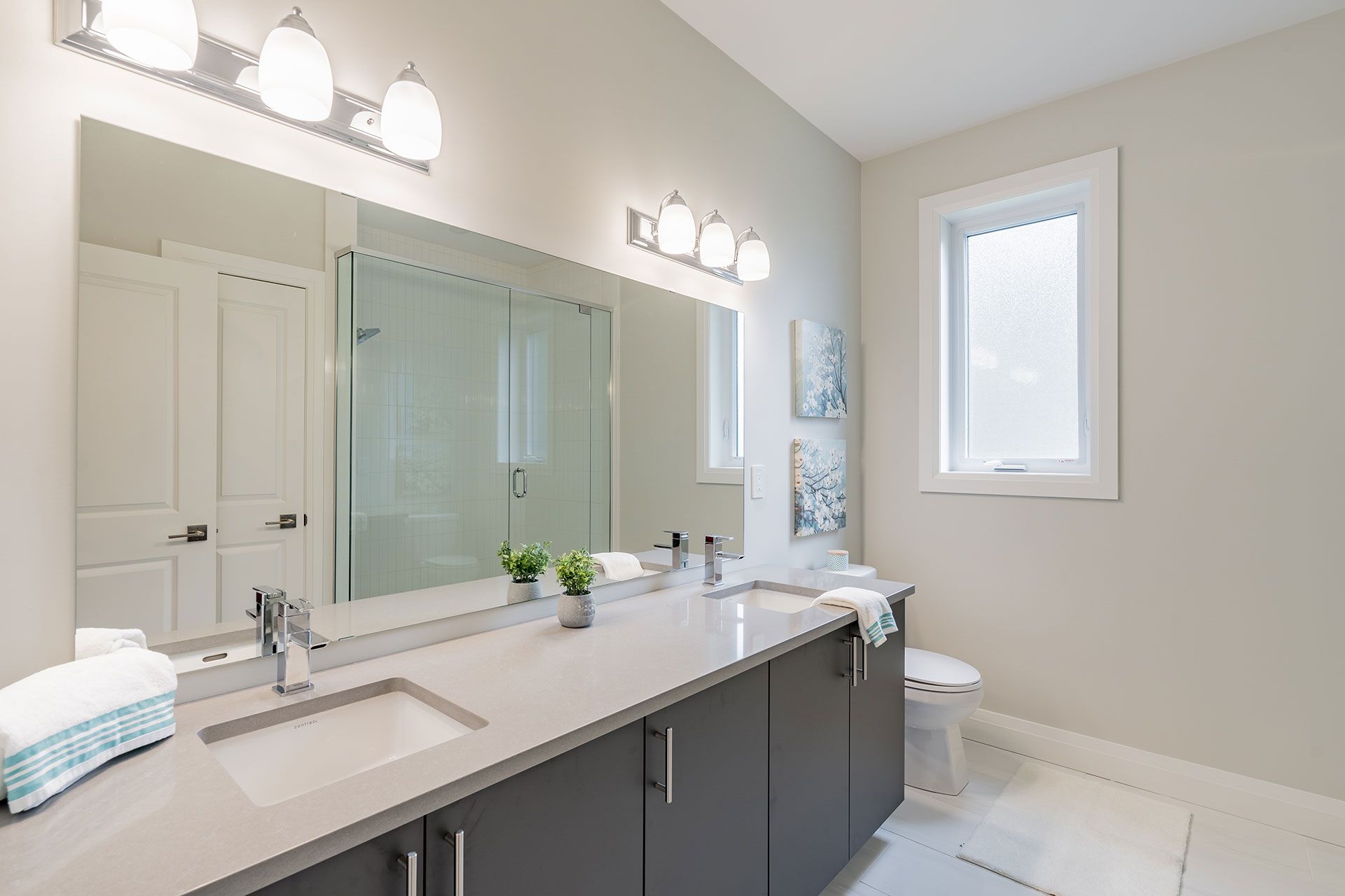 A bathroom with two sinks and a large mirror
