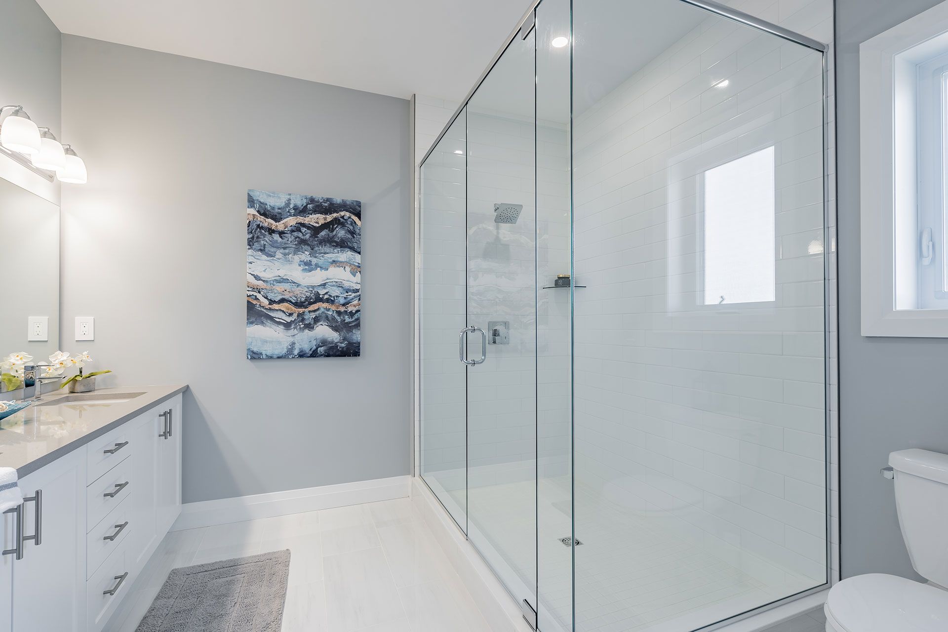 A bathroom with a walk in shower and a toilet in Fidelity Homes Signature build in Cramahe Township