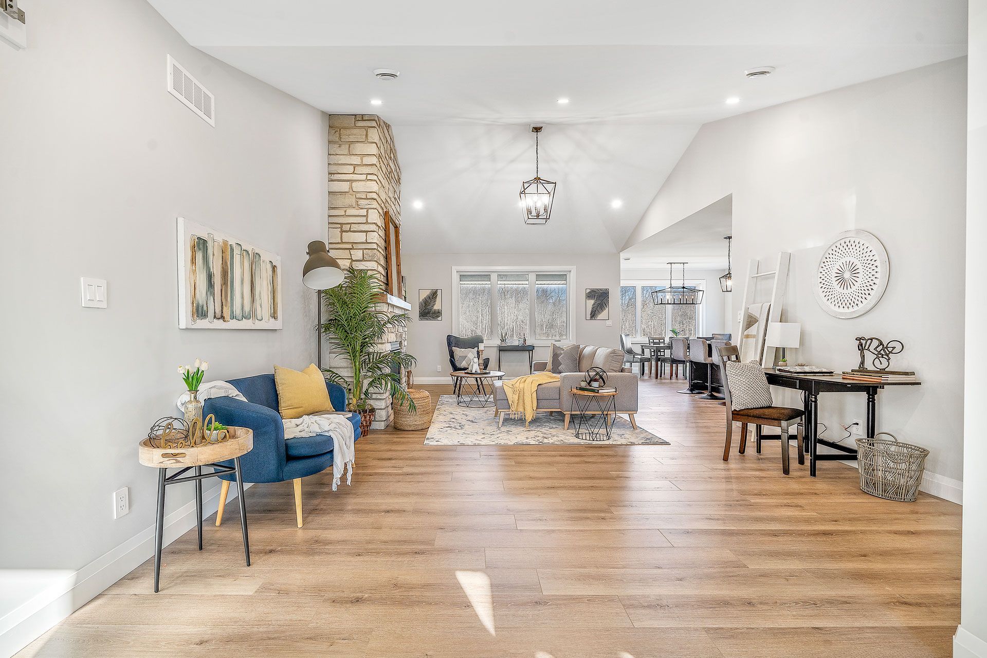 A living room with hardwood floors and a blue chair in Fidelity Homes Signature build in Brighton Ontario