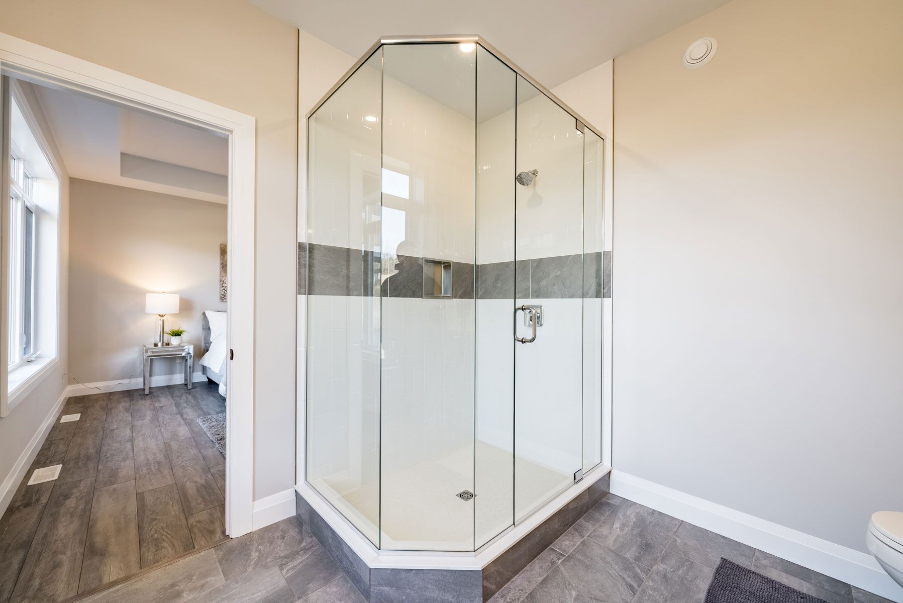 A bathroom with a walk in shower and a toilet in Fidelity Homes Signature build in Cramahe Township