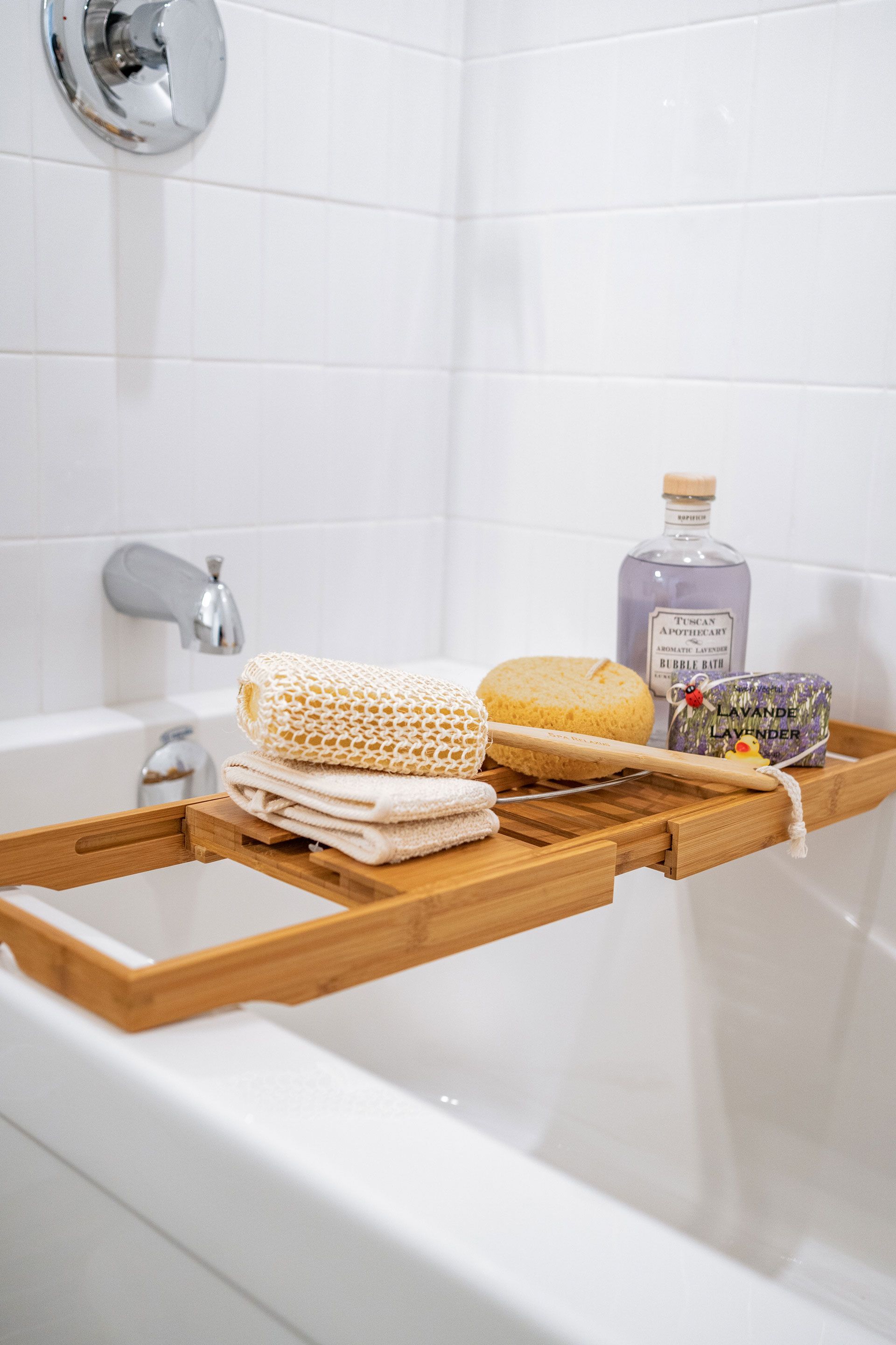 A bathtub with a wooden tray on top of it Fidelity Homes Signature build in Brighton Township