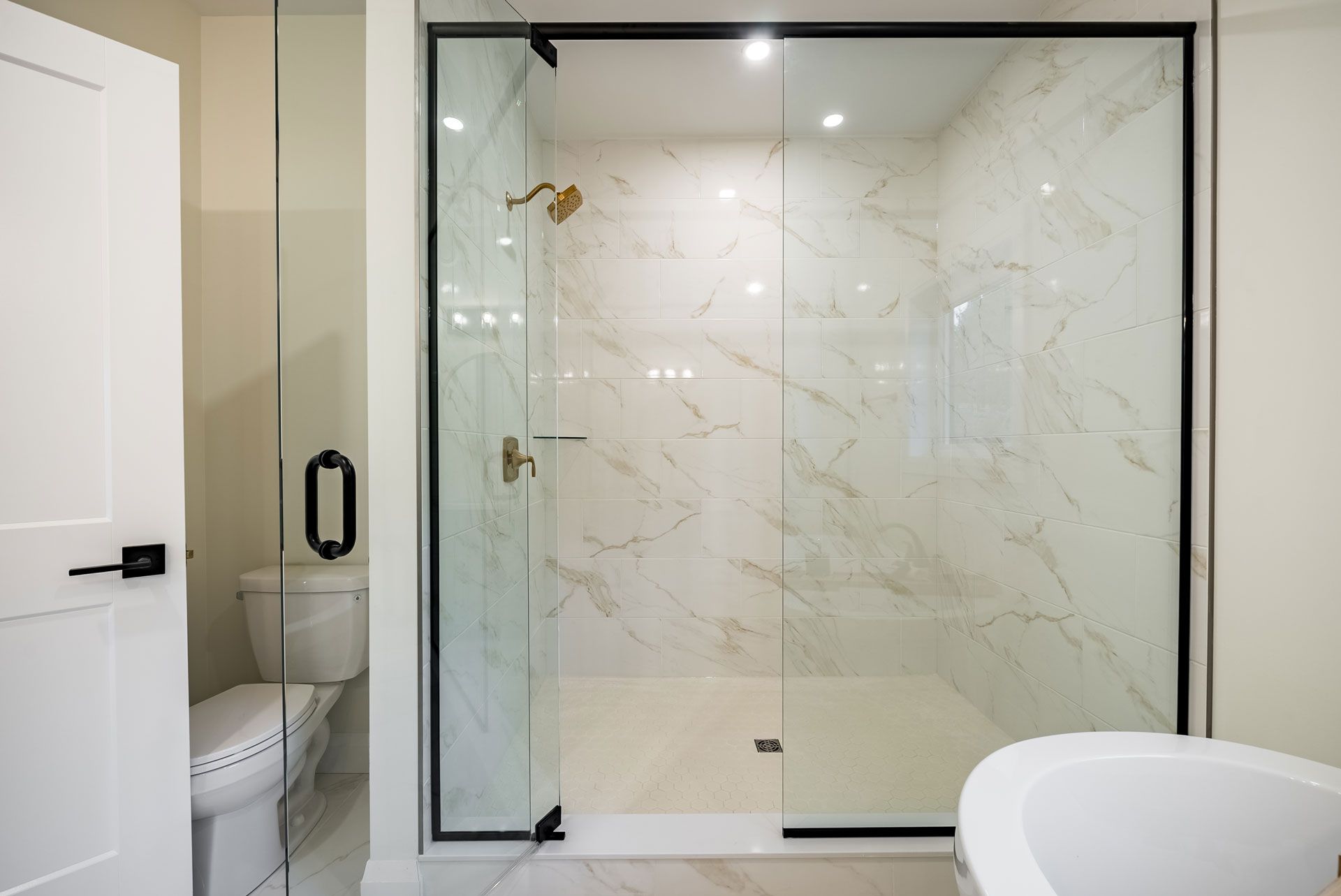 A bathroom with a walk in shower , toilet and bathtub Fidelity Homes Signature build in Cramahe Township