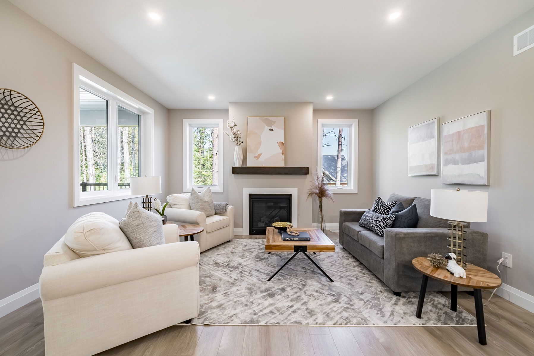 A living room with a couch and chairs and a fireplace in a Fidelity Homes Signature Build custom home in Castleton Ontario