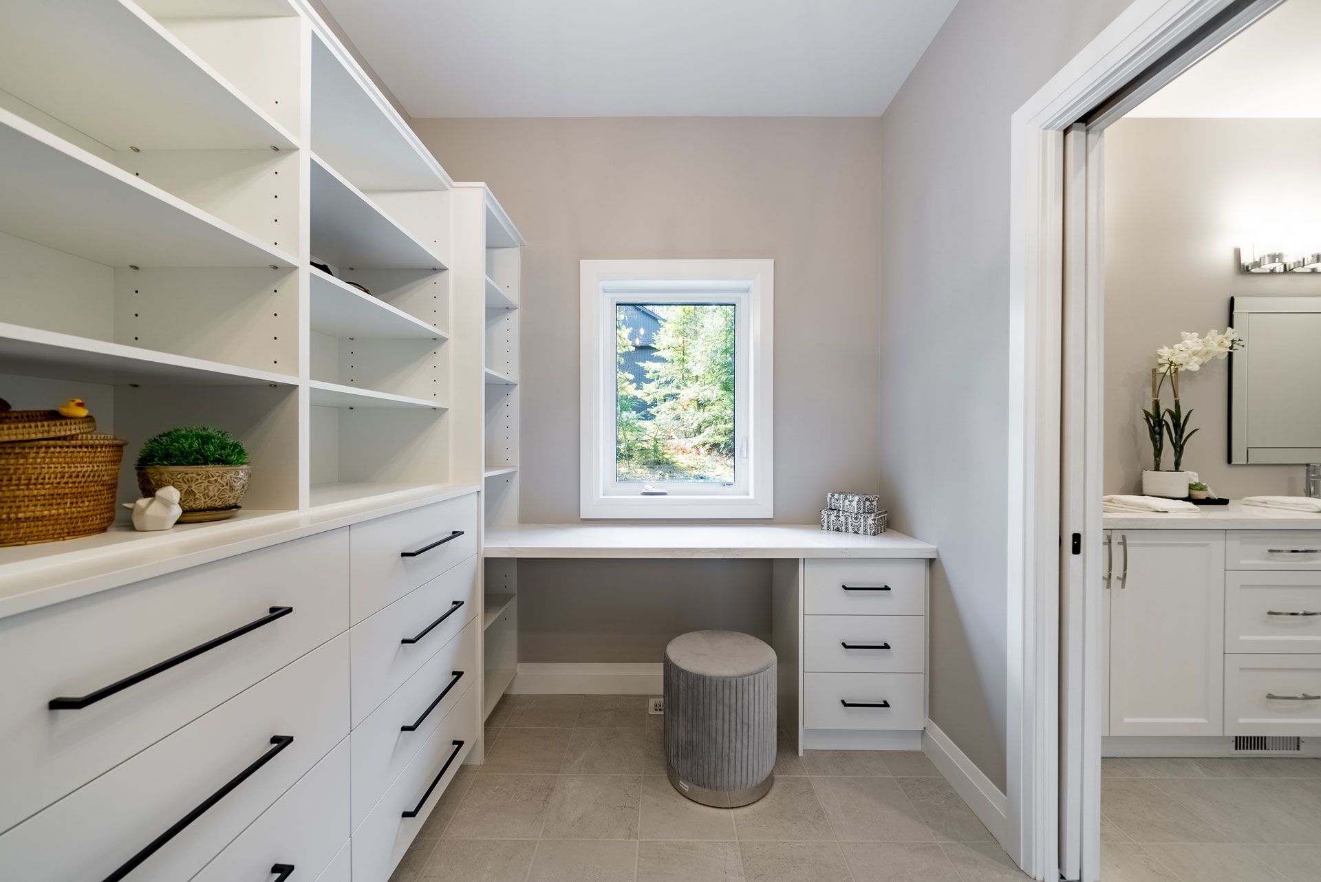 A walk in closet with lots of shelves and drawers and a window Fidelity Homes Signature build in Cramahe Township