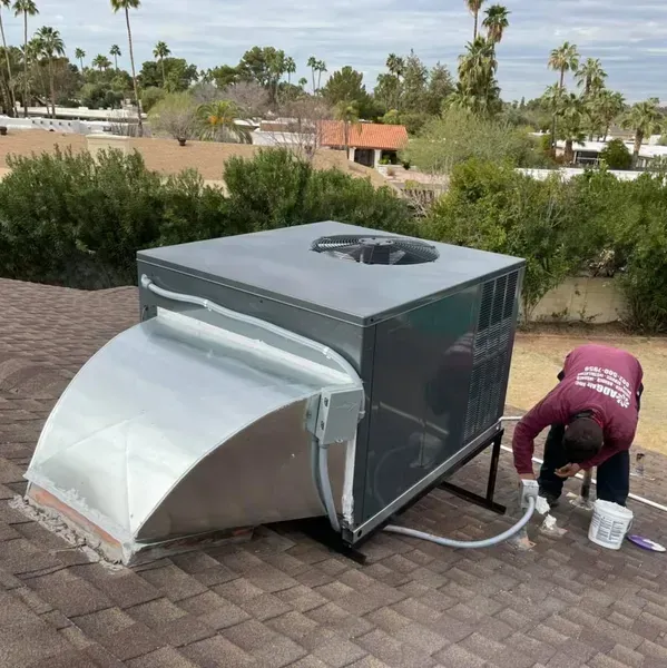 A man in a suit and glasses is smiling with his arms crossed.