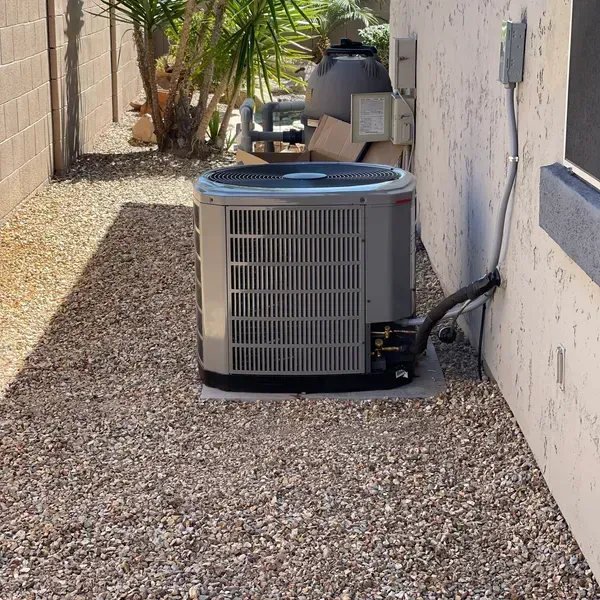 A man in a suit and glasses is smiling with his arms crossed.
