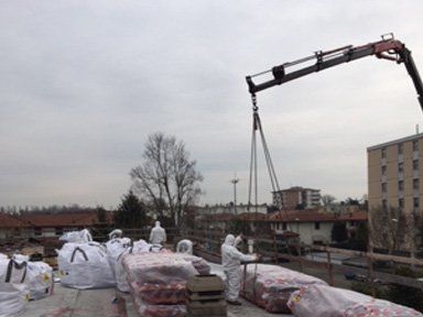 operai rimuovono materiale per copertura edile