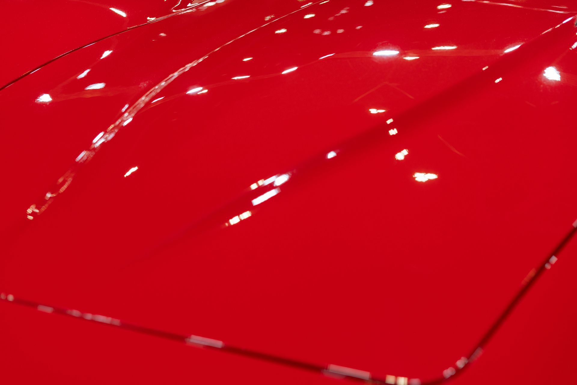 A close up of the hood of a red car