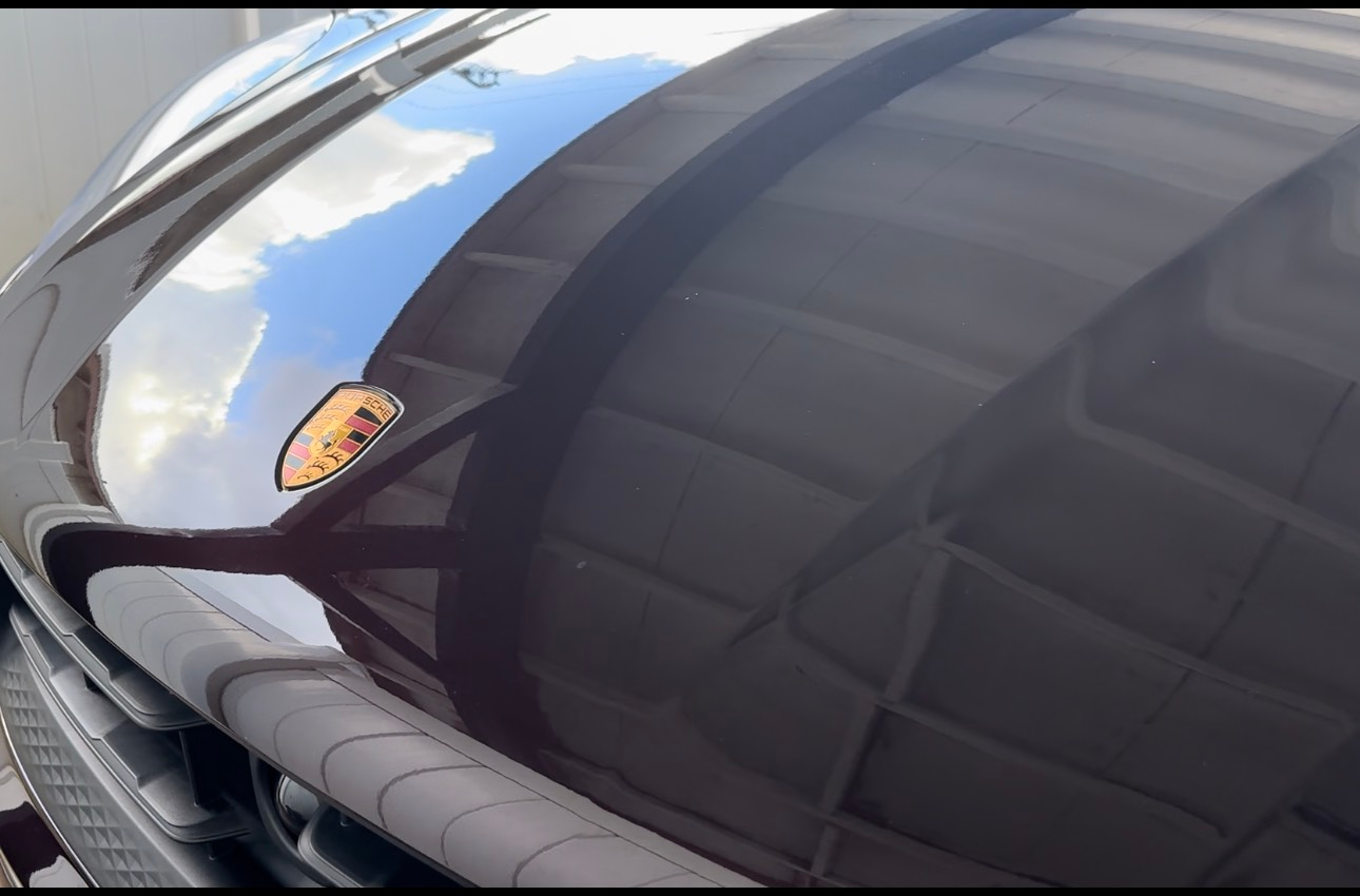 A black car with a porsche logo on the hood