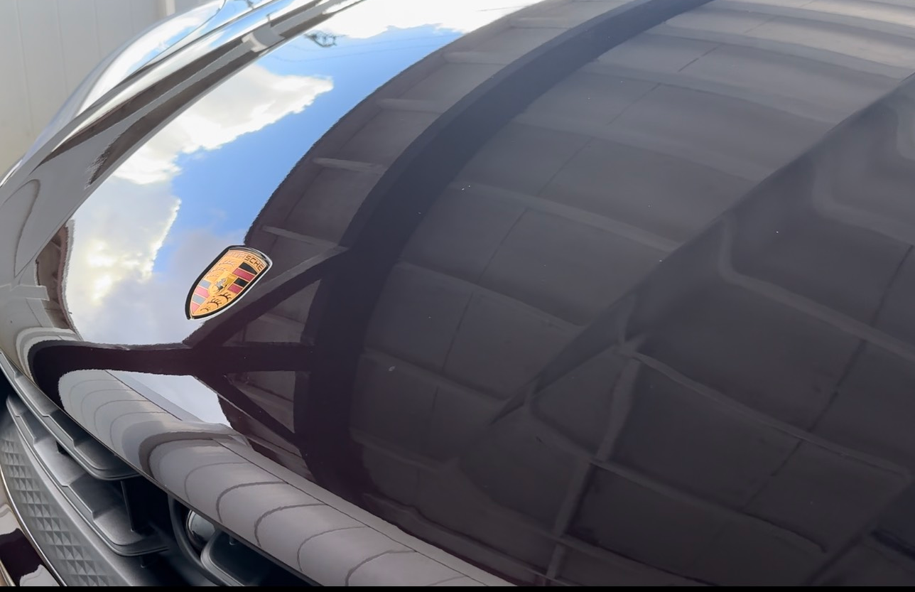 A black car with a porsche logo on the hood