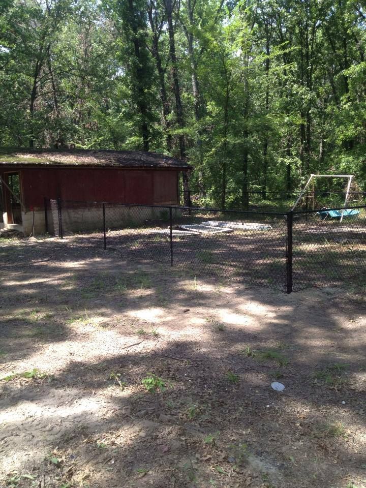 There is a red building in the middle of the woods.