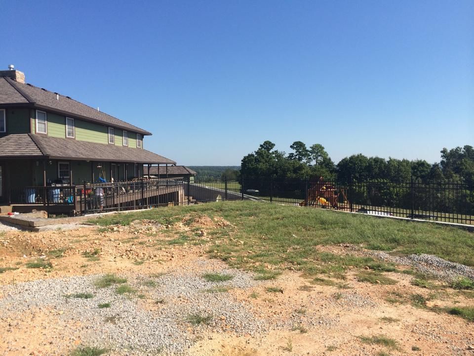 A large house is sitting on top of a hill next to a playground.
