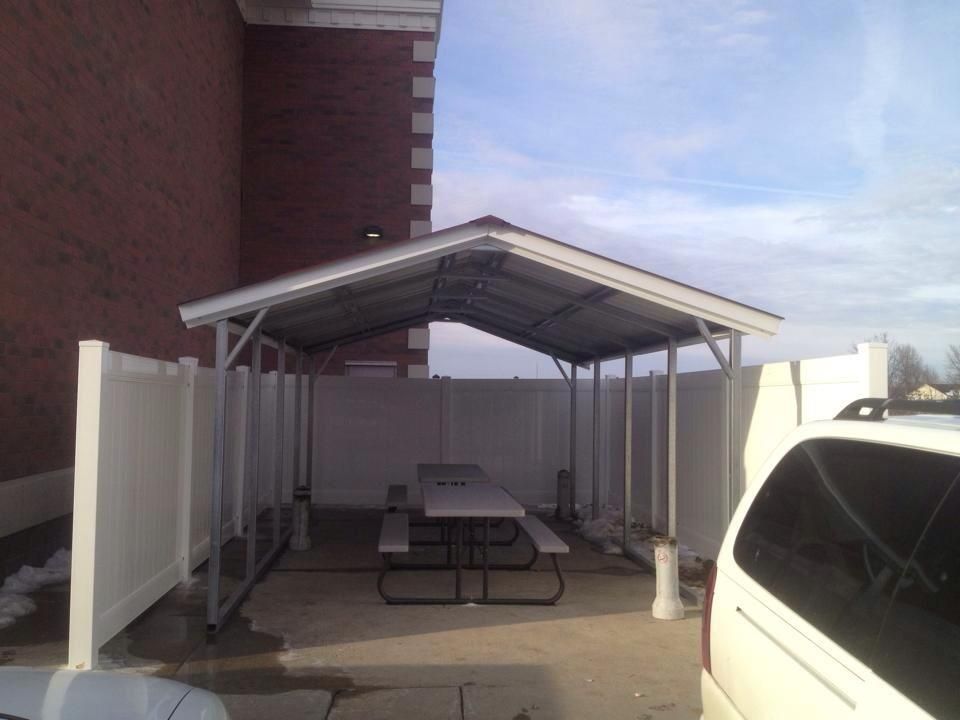 A wooden fence is in the backyard of a house.