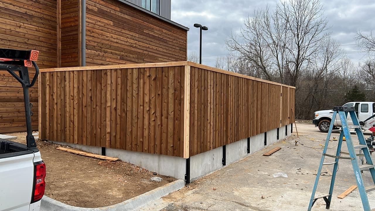 A wooden fence is being built in front of a building.