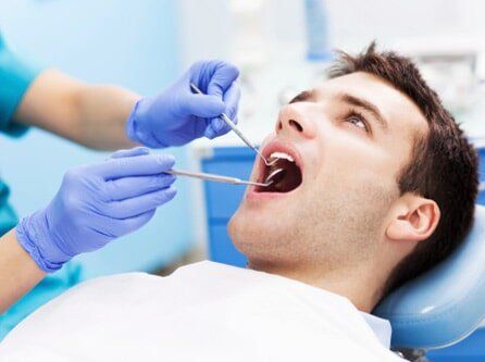 Man Having Teeth Examined at Dentists - Dental Exams in Lynbrook, NY