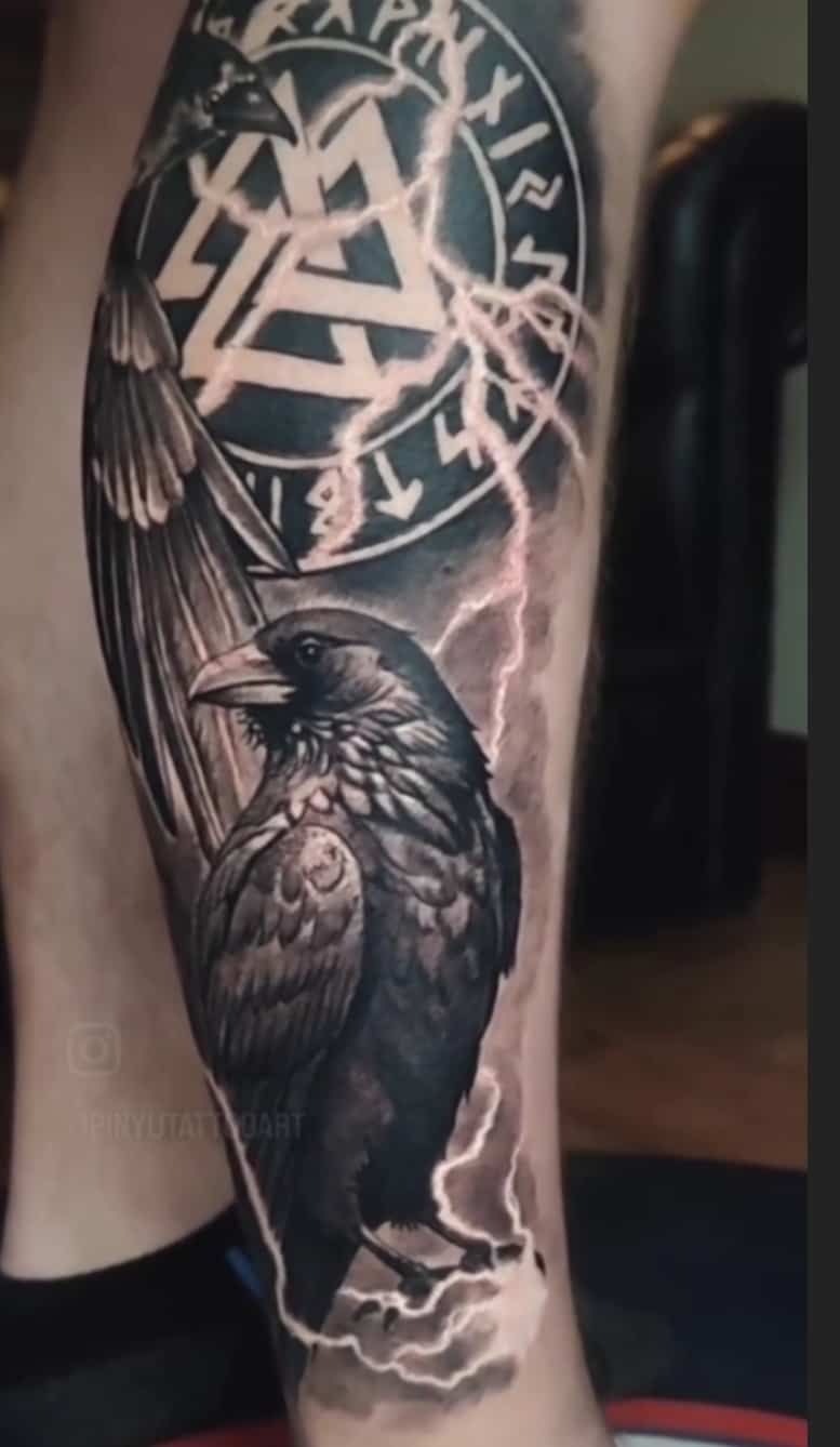 Tattoo of a raven with lightning and the Valknut symbol, surrounded by Norse runes.