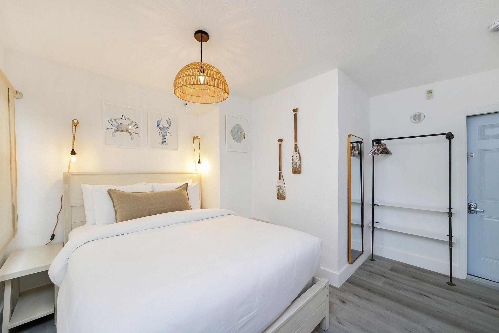 Bedroom with white walls, bed, decor, and blue door.