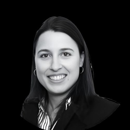 Woman in a blazer smiles. Black and white headshot.