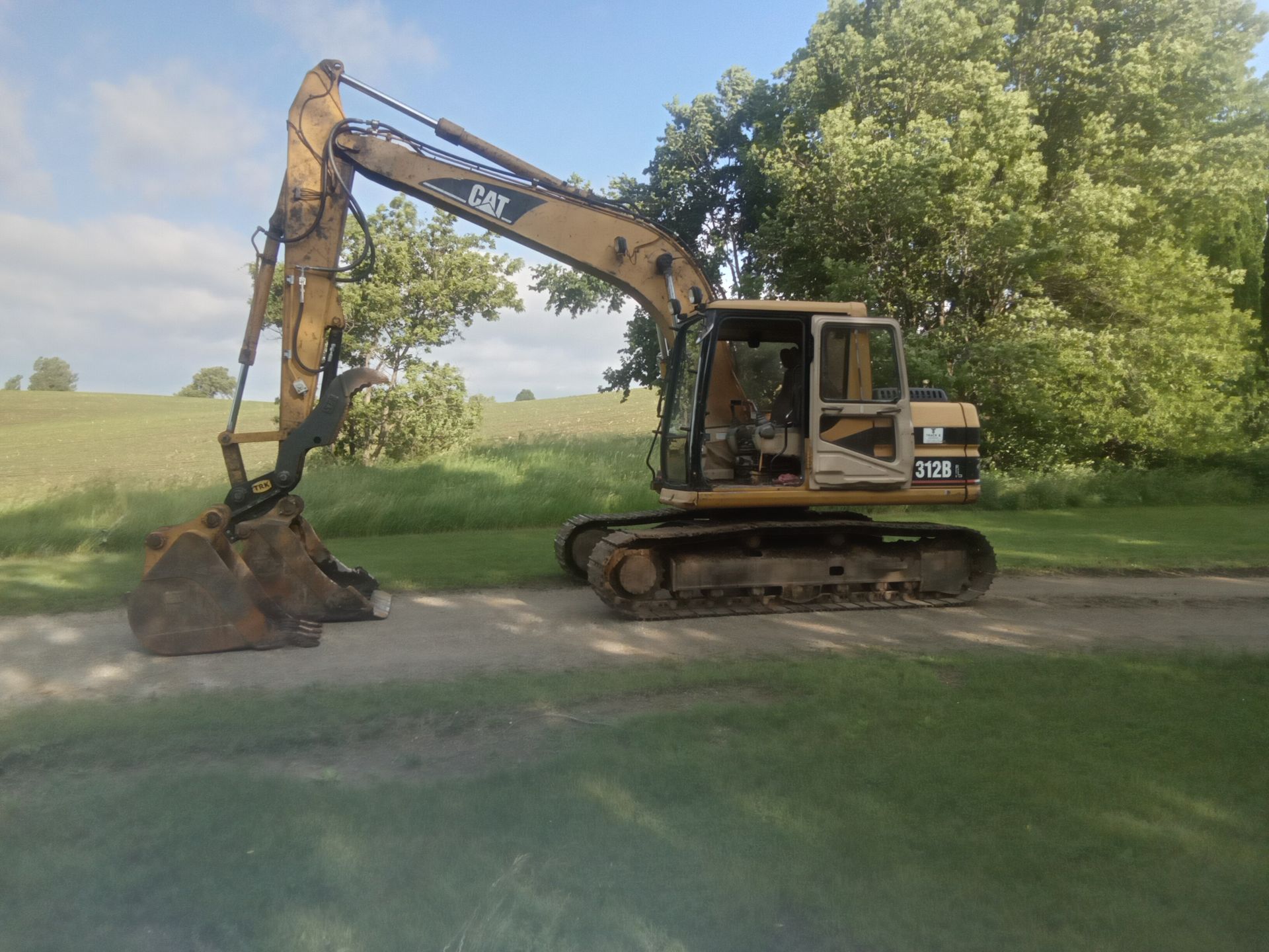 A yellow excavator is digging a hole in the dirt.
