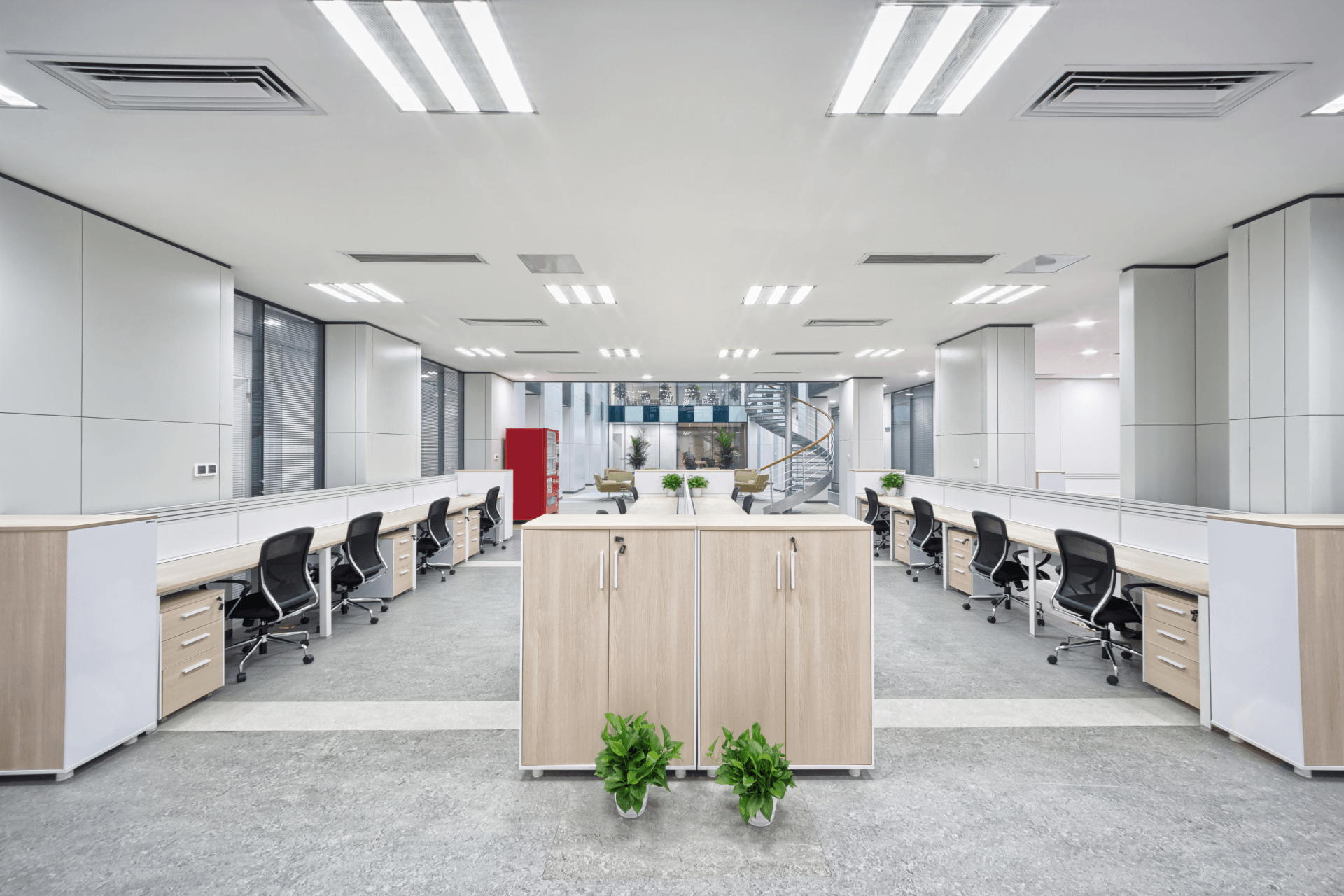 A large empty office with a lot of desks and chairs.