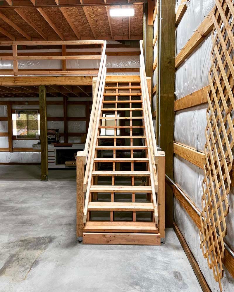 A wooden staircase leading up to a loft in a building