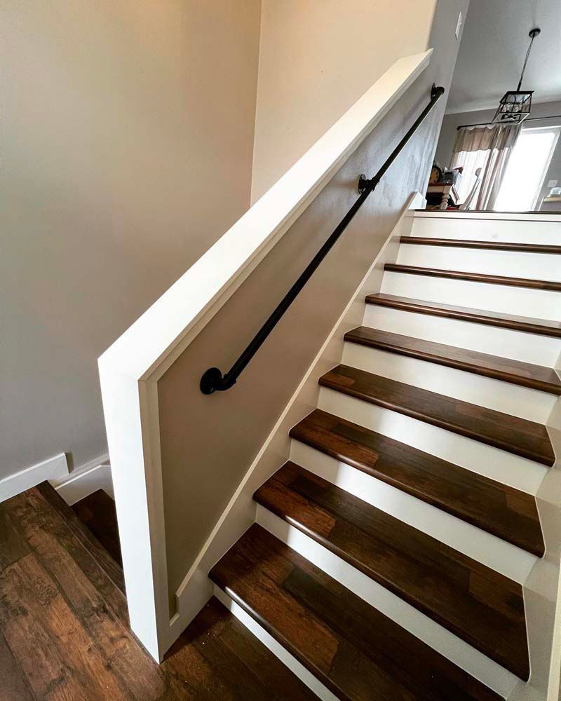 A staircase with wooden steps and a white railing in a house.