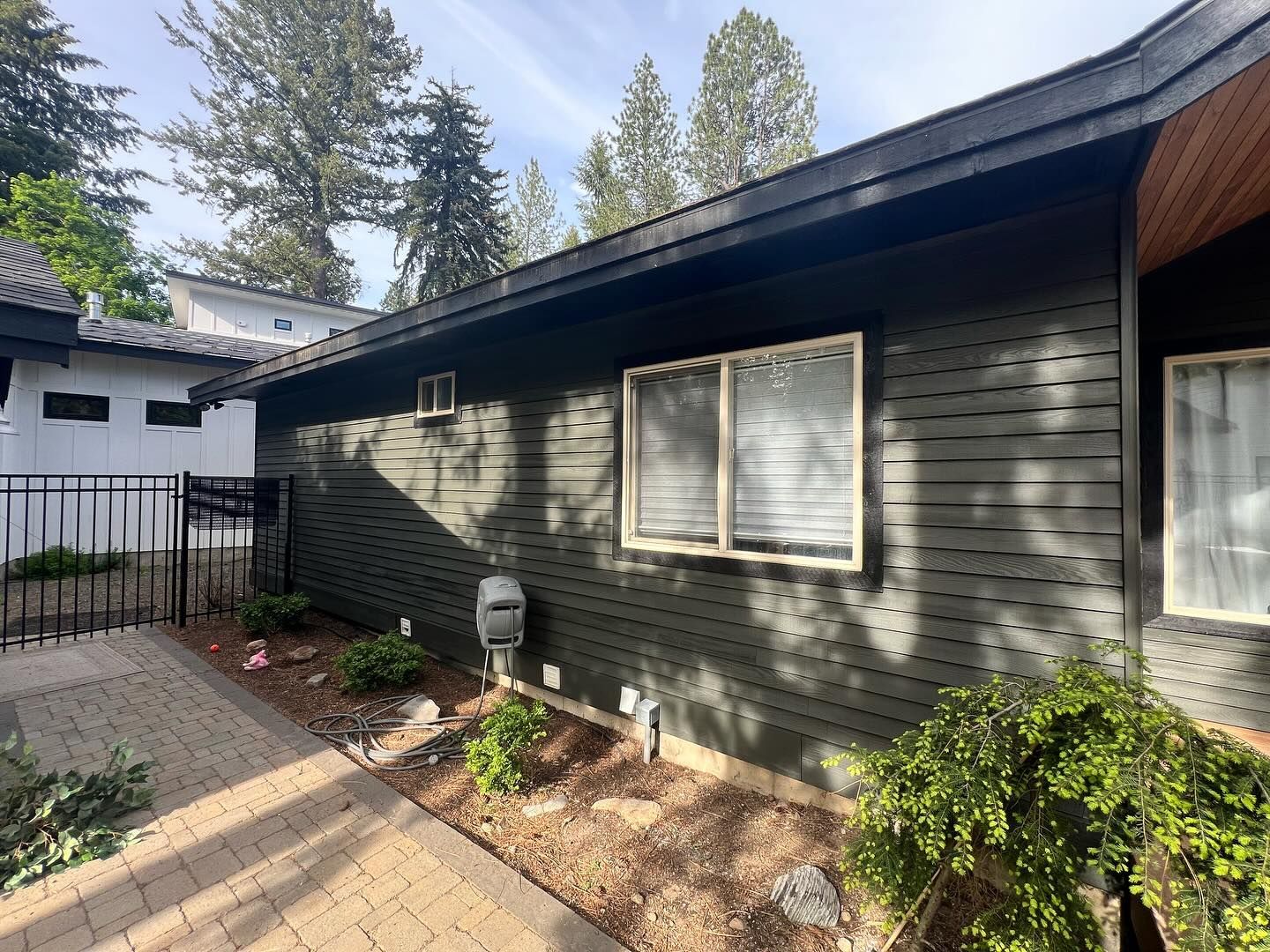 The side of a house with a fence and a lot of windows.