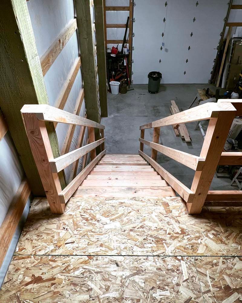 A wooden staircase is being built in a garage.
