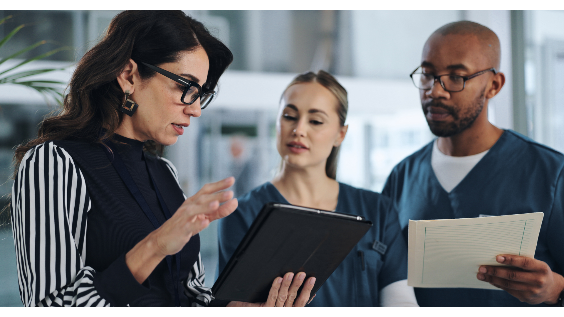Healthcare executive and employees looking at tablet