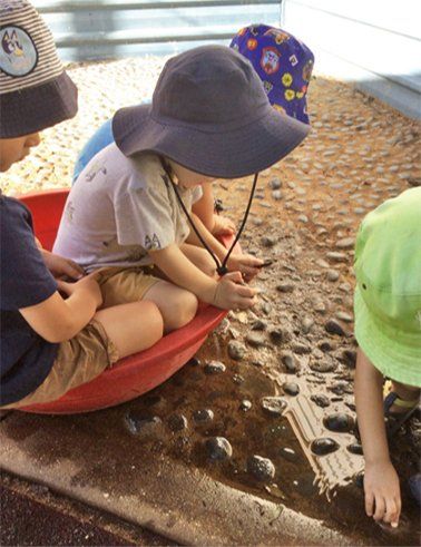 Children playing with pebbles — Gap Community Child Care Centre In Alice Springs, NT