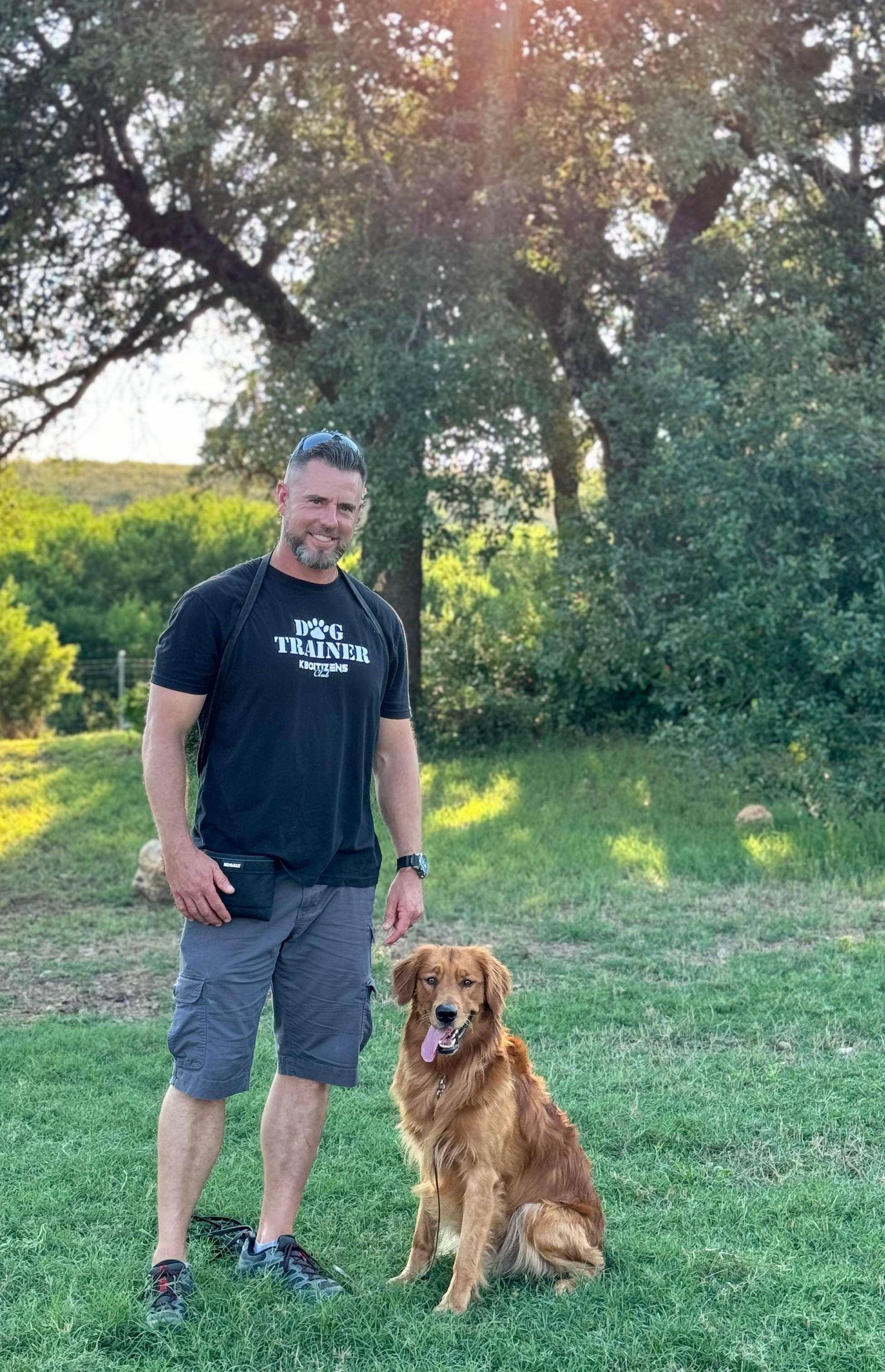 Man and golden retriever dog outside, man smiling, dog sitting, sunny day.