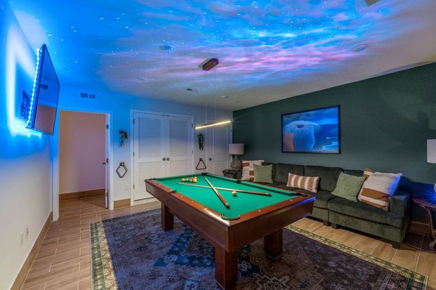 There is a pool table in the middle of the room.