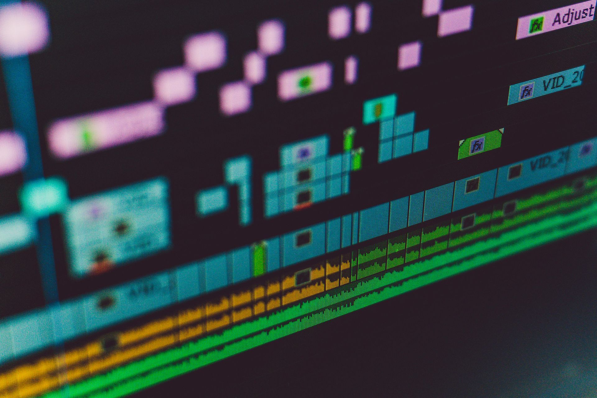 Video editing software interface; timeline with various color-coded clips and audio tracks.
