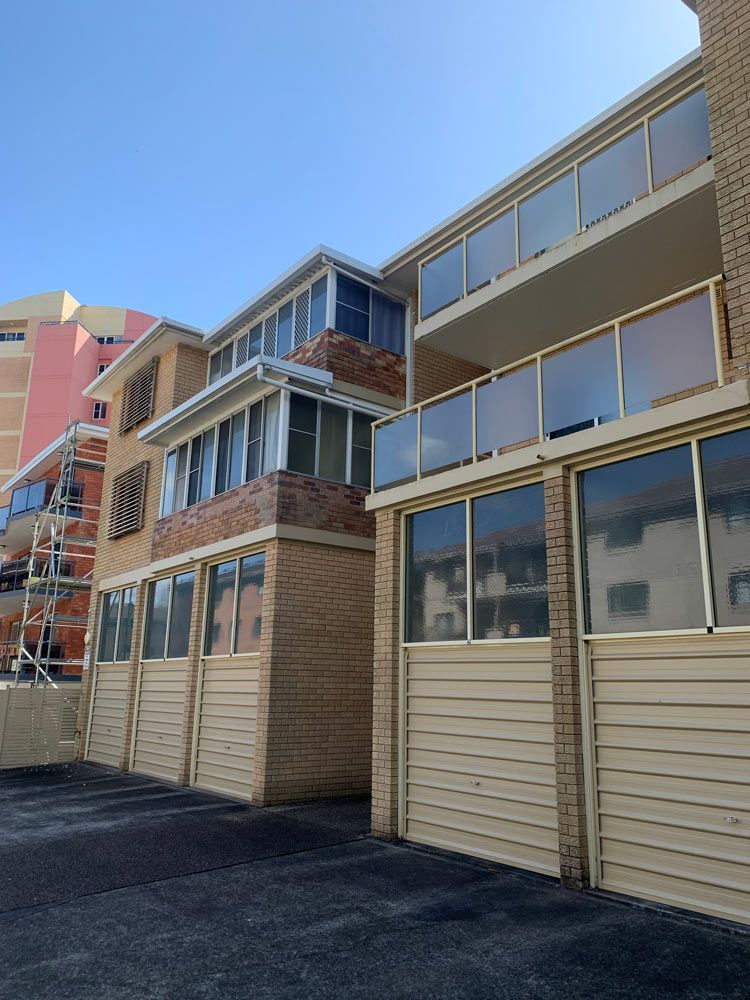 Apartment Building With Garage Doors — Commercial Painting in Forster