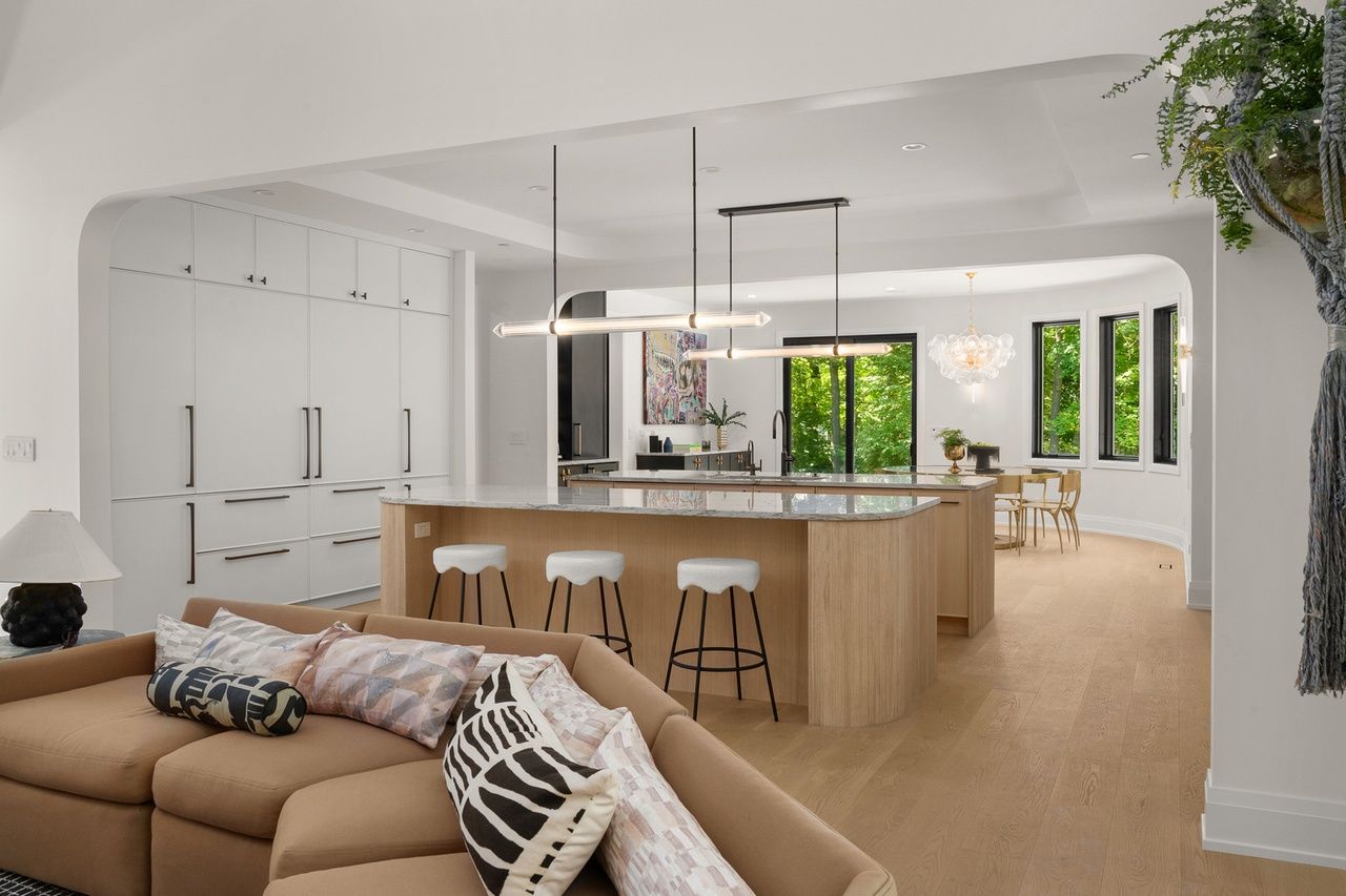 A living room with a couch and a kitchen in the background.