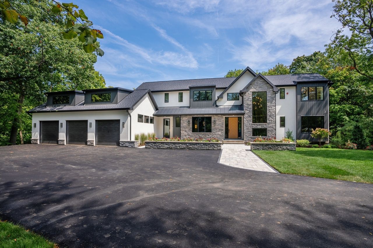 A large house with a lot of windows and a driveway in front of it.