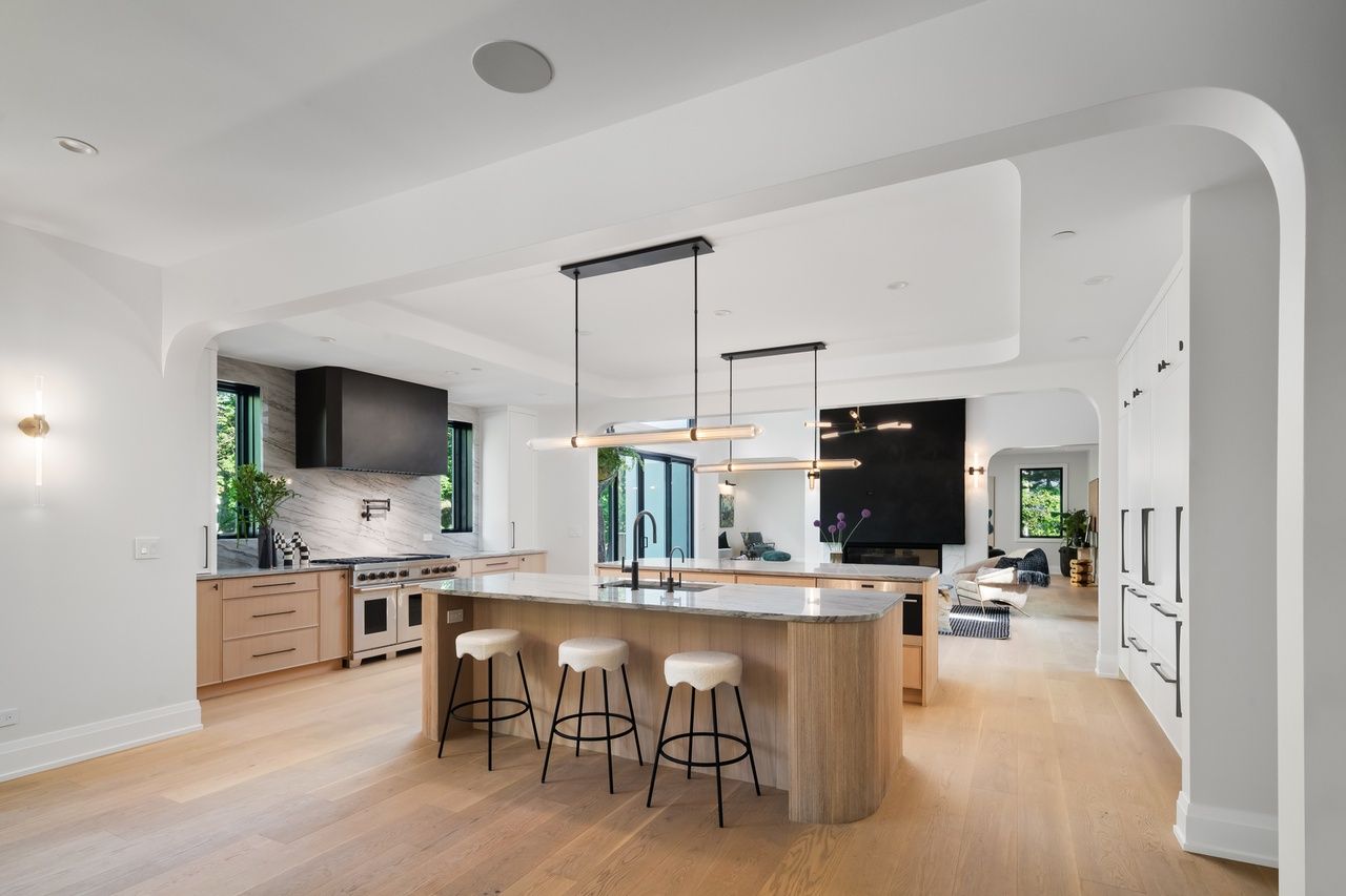 A kitchen with a large island and stools in it