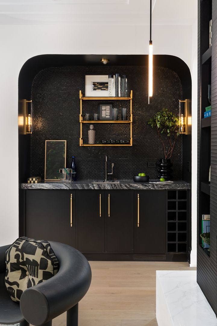 A kitchen with black cabinets and a marble counter top