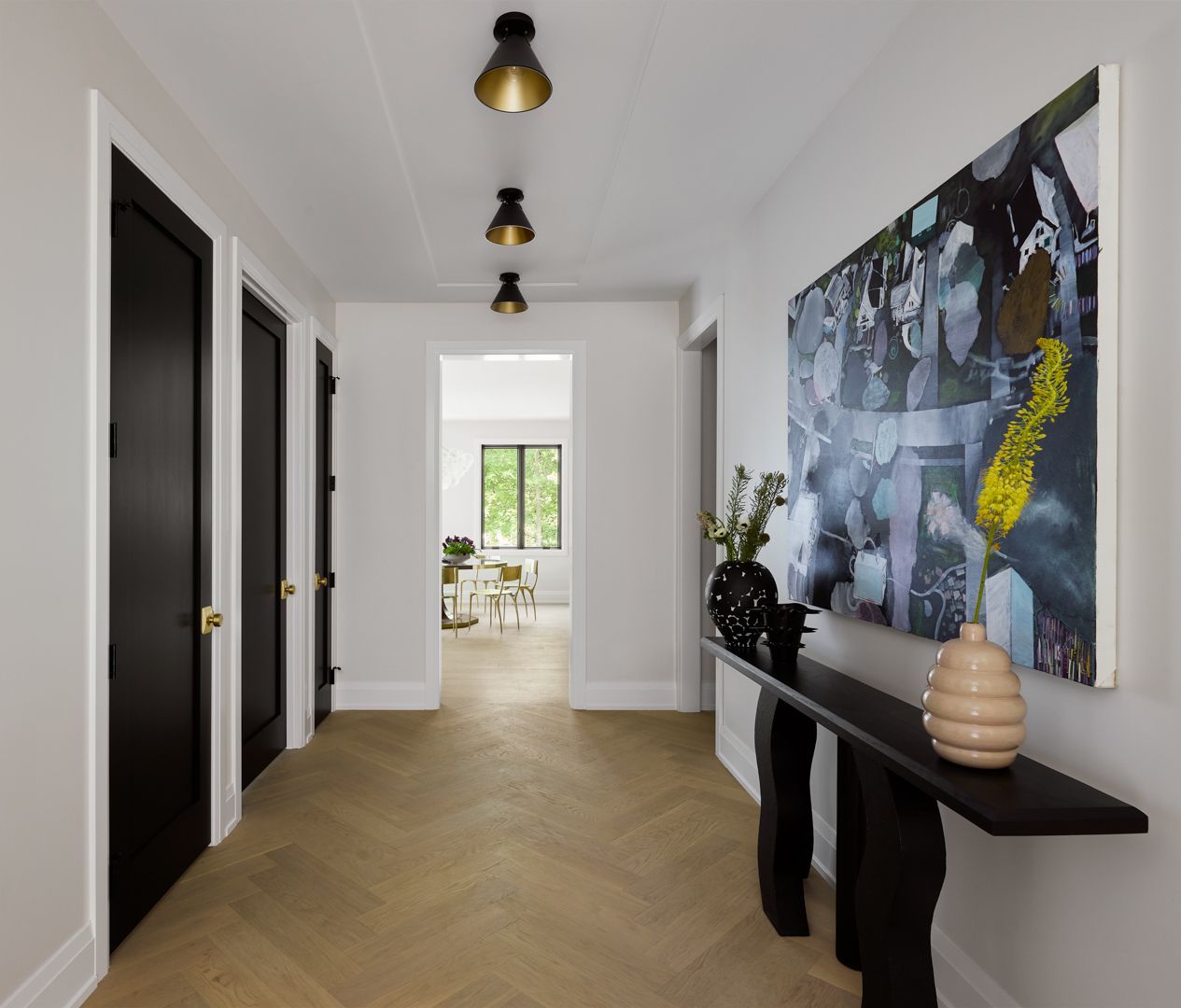 A hallway with a table and a painting on the wall