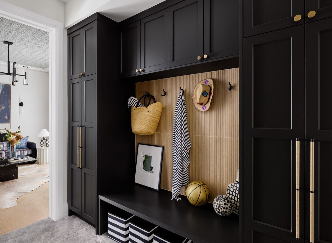 A mud room with black cabinets and a bench.