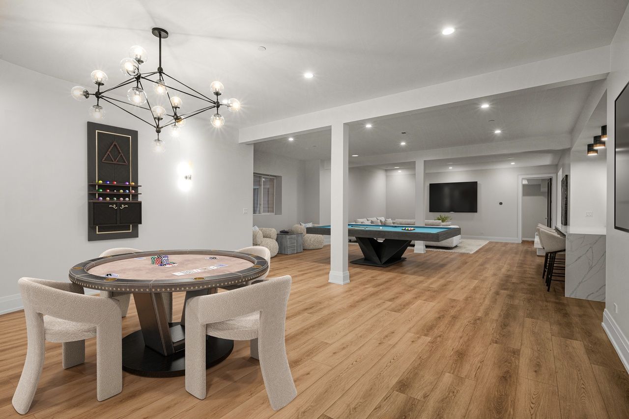 A game room with a table and chairs and a pool table.