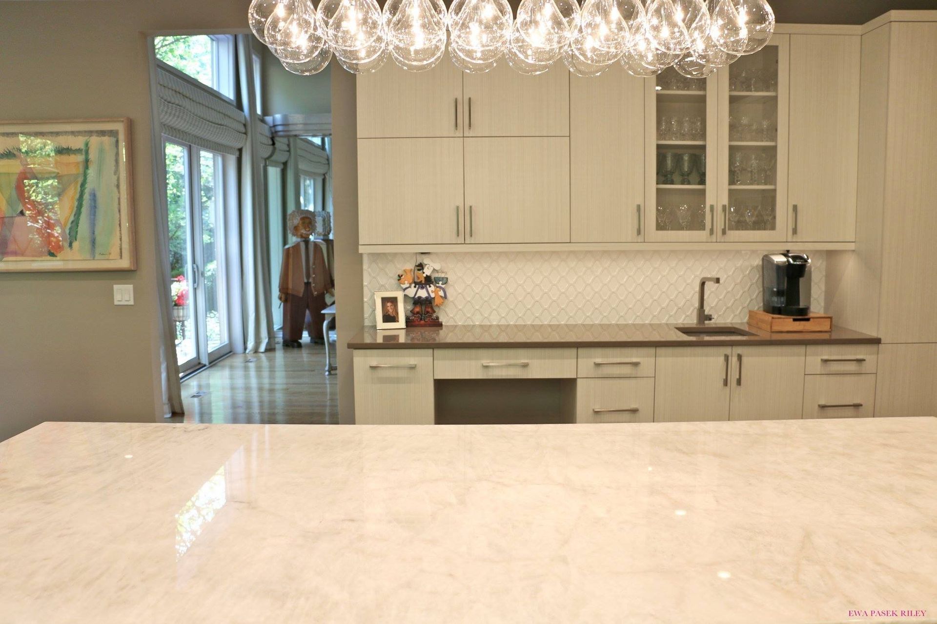 A kitchen with white cabinets and a large counter top